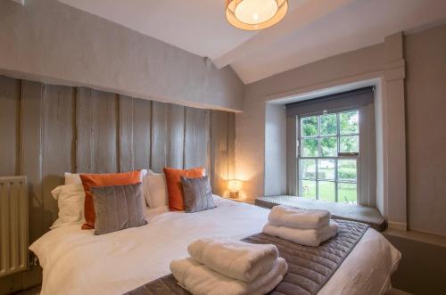 a bedroom with a large bed with pillows and a window at The Church House in Torver