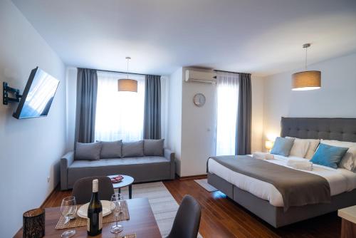 een slaapkamer met een bed, een bank en een tafel bij Apartman Paradiso 211 in Vrnjačka Banja