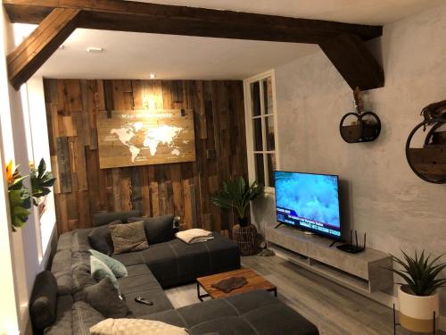 a living room with a couch and a flat screen tv at casa Heemskerk in Noordwijk