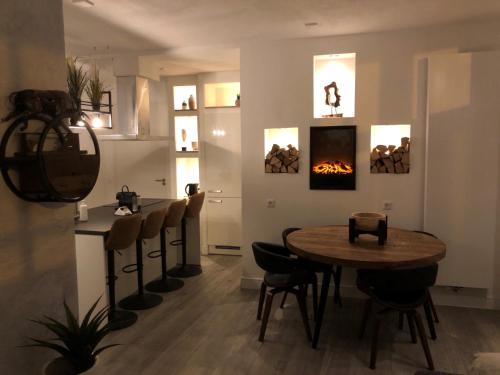 a dining room with a table and a fireplace at casa Heemskerk in Noordwijk