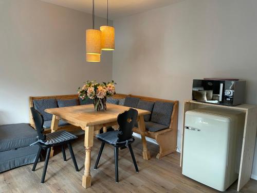 a dining room with a table and chairs and a refrigerator at Amelie Ferienwohnung in Garmisch-Partenkirchen