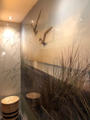 a room with two stools and birds on the wall at casa Heemskerk in Noordwijk