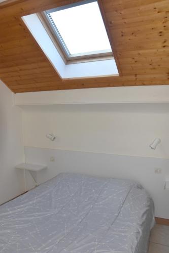 a skylight in a bedroom with a bed at Hotel Gai Relais in Gérardmer