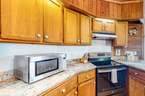 a kitchen with wooden cabinets and a stainless steel microwave at Dome Home in Indian Pass