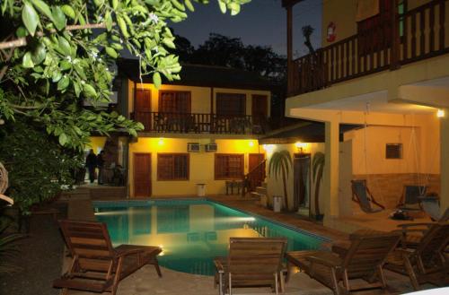 una piscina frente a una casa por la noche en Hostel Peter Pan en Puerto Iguazú