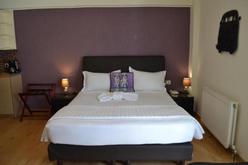 a bedroom with a large white bed with a purple headboard at Rivitel Marousi Apartments in Athens