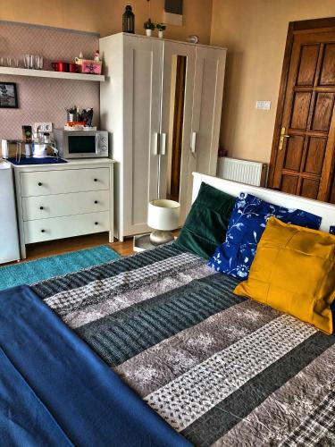 a bedroom with a bed with blue sheets and yellow pillows at Villa Borostyán in Tihany