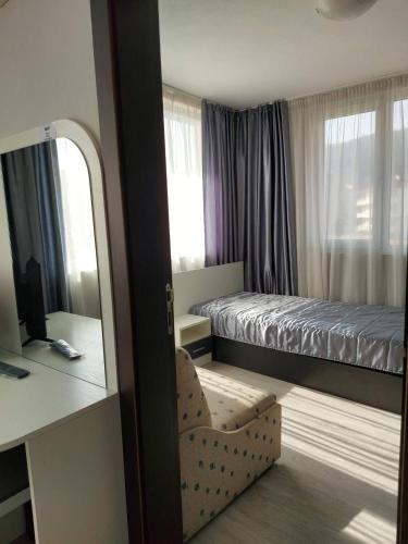 a small bedroom with a bed and a mirror at Guest House Perla in Obzor