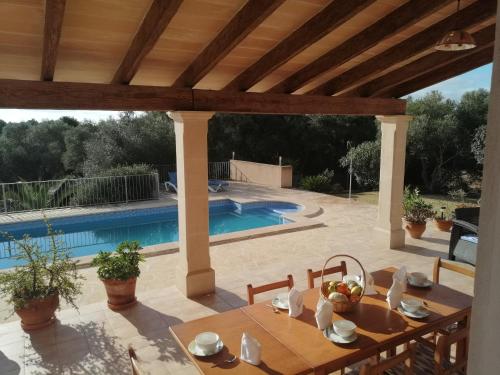 a patio with a table and a swimming pool at Villa Rito Nou in Felanitx