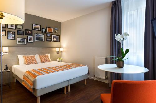 モンペリエにあるシタディーン アパートホテル モンペリエ アンティゴーンのベッドとテーブルが備わるホテルルームです。