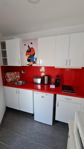 a kitchen with white cabinets and a red counter top at Cura Sol in Playa del Cura