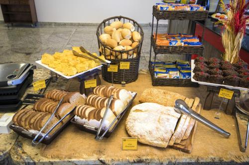 a display of bread and other foods on a table at Hotel Dan Inn Campinas Anhanguera - By Nacional Inn in Campinas
