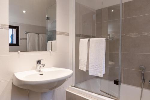 a white bathroom with a sink and a shower at Résidence Marie Diane - Grand Duplex H in Propriano