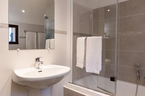 une salle de bain blanche avec un lavabo et une douche dans l'établissement Résidence Marie Diane - Grand Duplex H, à Propriano