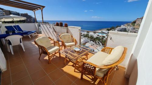 a balcony with chairs and a table and the ocean at Cura Sol in Playa del Cura