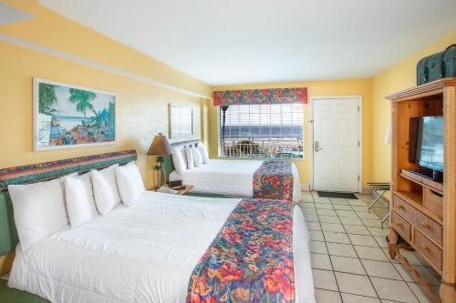 a hotel room with two beds and a television at Sea Shells Beach Club in Daytona Beach