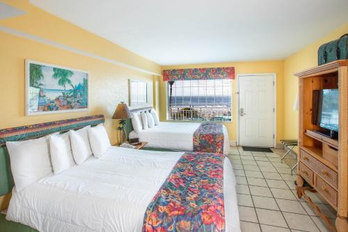 a hotel room with two beds and a television at Sea Shells Beach Club in Daytona Beach