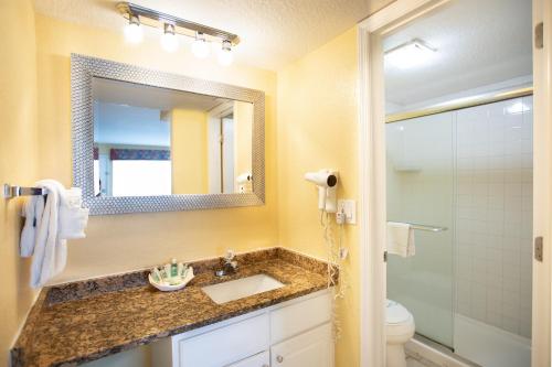 a bathroom with a sink and a mirror at Sea Shells Beach Club in Daytona Beach