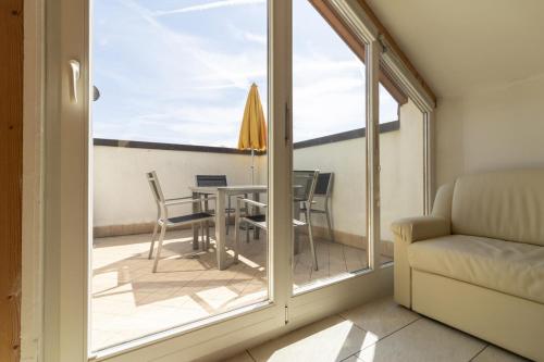 a room with a balcony with a table and chairs at Stompferhof Mansarde in Caldaro