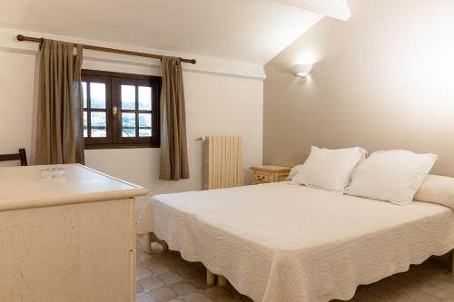une chambre avec un lit avec des draps blancs et une fenêtre dans l'établissement Résidence Marie Diane - Grand Duplex H, à Propriano