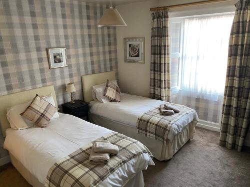 a bedroom with two beds and a window at The Queens in St Bees