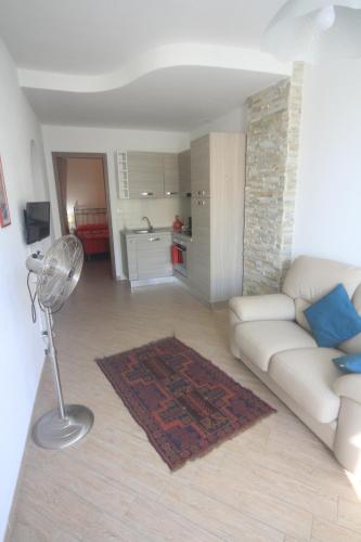 een woonkamer met een witte bank en een keuken bij Vernazza Vacation 2 in Vernazza