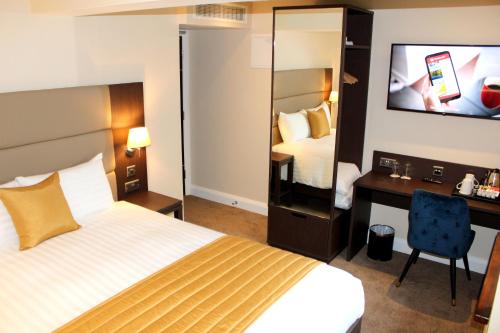 a hotel room with a bed and a desk and a television at Joyce's Carndonagh Inishowen in Carndonagh