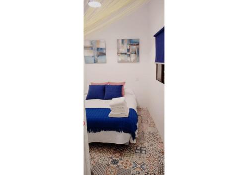 ベヘール・デ・ラ・フロンテーラにあるCasa Trianaのベッドルーム1室(青と白のシーツが備わるベッド1台付)