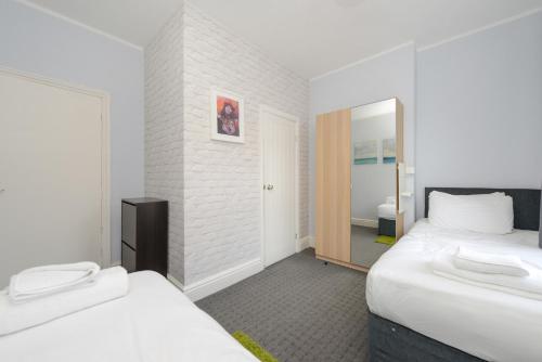 Habitación de hotel con 2 camas y espejo en Perfect for Contractors! Spacious 5bed house with Parking - Radford en Nottingham