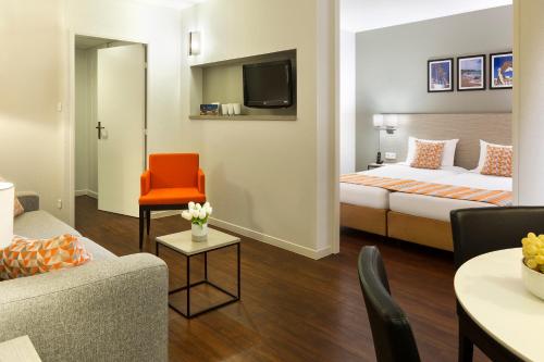 a hotel room with a bed and a living room at Citadines Antigone Montpellier in Montpellier