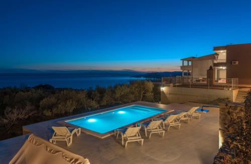 a villa with a swimming pool at night at Villa Violeta With Amazing Sea View in Makarska