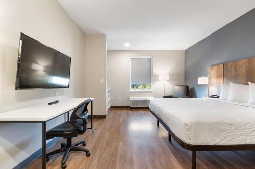 a bedroom with a bed and a desk and a tv at Extended Stay America Premier Suites - Melbourne - I-95 in West Melbourne