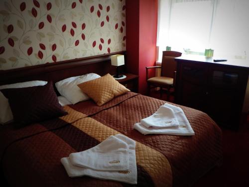 a hotel room with a bed with towels on it at Apartamenty przy Głównym Deptaku in Wisła