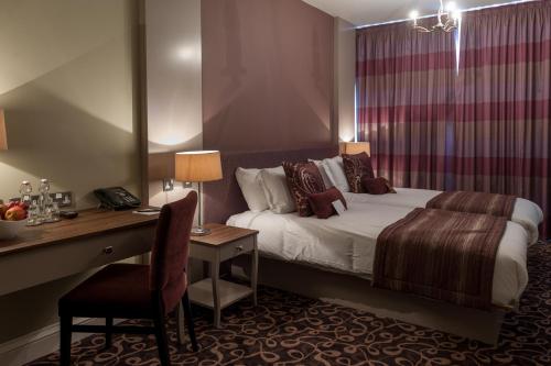 um quarto de hotel com uma cama e uma secretária com uma cadeira em Halifax Hall em Sheffield