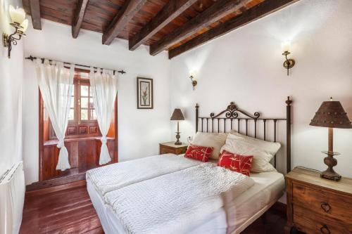 Un dormitorio con una cama con almohadas rojas. en Finca Los Viñedos Casa Rural en Tacoronte