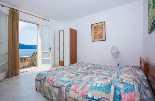 ein Schlafzimmer mit einem Bett und einem großen Fenster in der Unterkunft Holiday Home Ratac Sunshine Beach in Slano