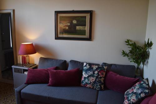 a blue couch with pillows in a living room at Al Carmine Apartments Towers view with AC in Lucca