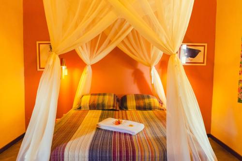 a bedroom with a canopy bed with a white plate on it at Vila Clara do Capão in Vale do Capao