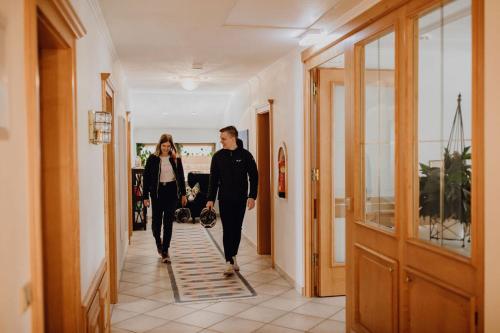 a man and a woman walking down a hallway at Dorfcafe Unken Hotelpension sWirtshaus im Dorf in Unken