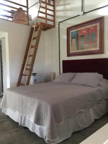 a bedroom with a bed with a ladder on the wall at Parador Algaroba in Japaratinga