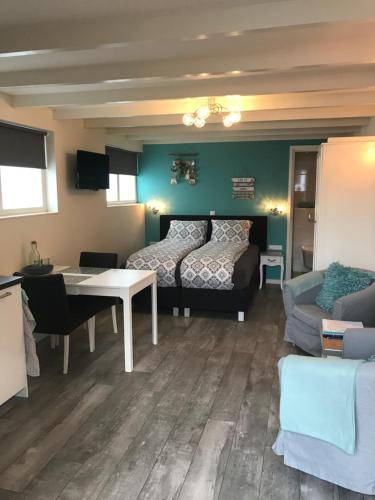 a room with a bed and a table and a couch at Mikasabeach in Zandvoort