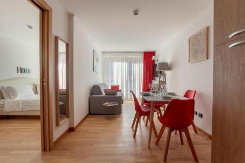 a living room with a table and chairs and a bedroom at Gressoney Saint-Jean apartments by Halldis in Gressoney-Saint-Jean
