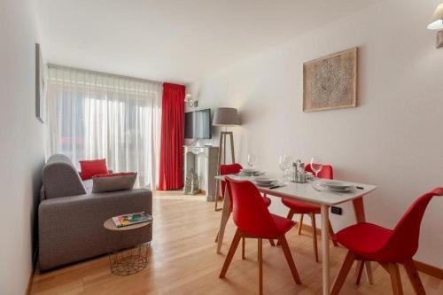 a living room with a table and red chairs at Gressoney Saint-Jean apartments by Halldis in Gressoney-Saint-Jean