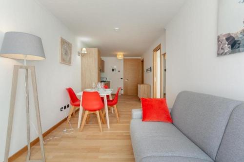 a living room with a couch and red chairs at Gressoney Saint-Jean apartments by Halldis in Gressoney-Saint-Jean