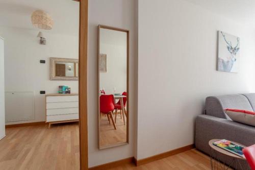 a mirror in a living room with a couch and a table at Gressoney Saint-Jean apartments by Halldis in Gressoney-Saint-Jean