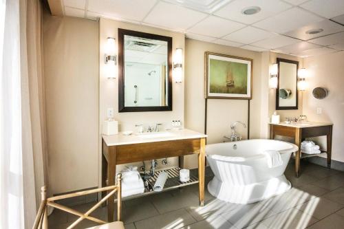 a bathroom with a tub and a toilet and a sink at Crowne Plaza Charleston by IHG in Charleston