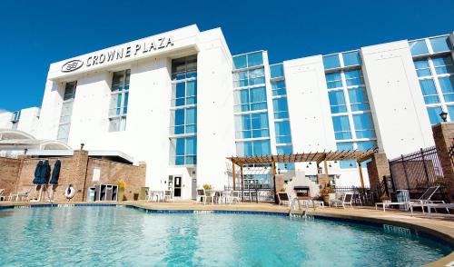 a hotel with a swimming pool in front of a building at Crowne Plaza Charleston by IHG in Charleston