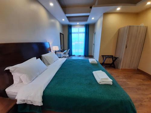 a bedroom with a large bed with two towels on it at Shalom Farmhouse by the hillside in Imphal