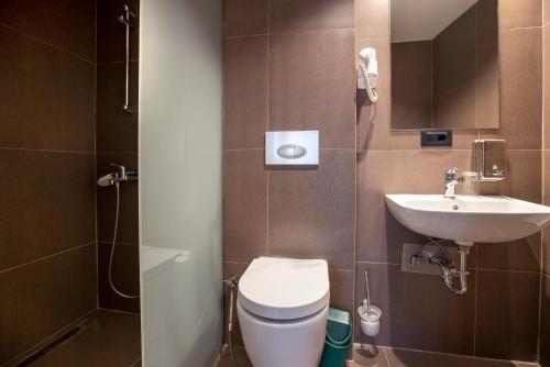 Hotel 4 Llulla في بريشتيني: حمام مع مرحاض ومغسلة