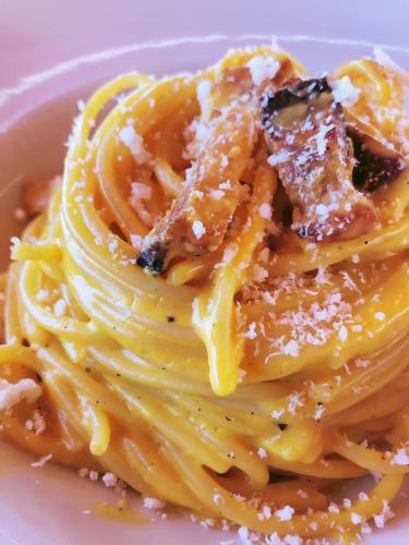 a plate of pasta with sauce and cheese on it at ISOLA VERDE Camping Village in Nettuno